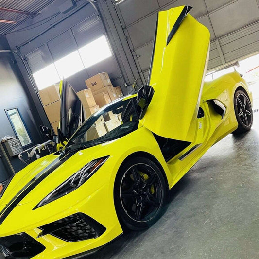 Yellow sports car with C8 vertical doors at-home installation open inside garage