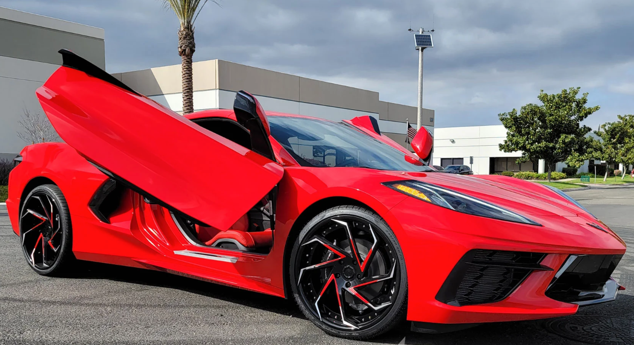 Red C8 Corvette with C8 Corvette butterfly door kit installed outdoors by Vertical Doors Inc