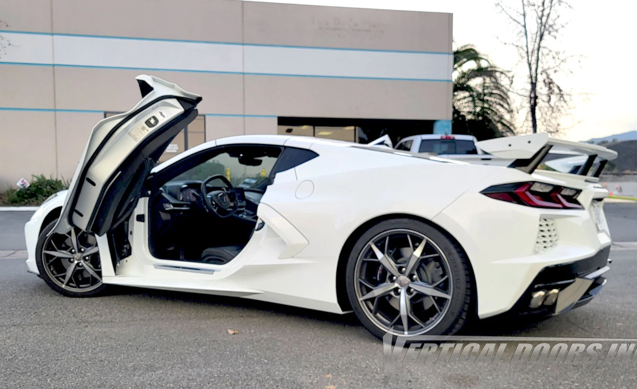 White C8 Corvette with C8 Corvette butterfly door kit installed, showing open butterfly doors