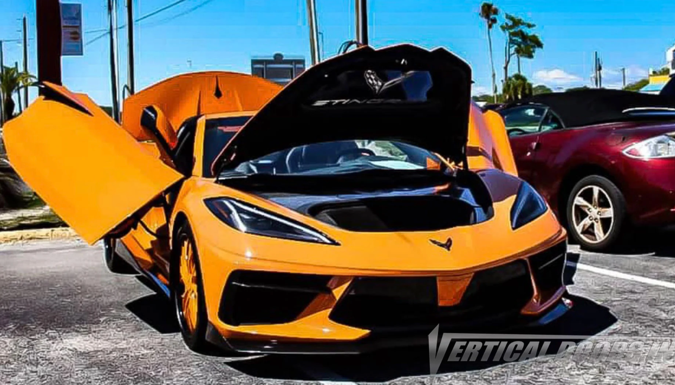 Yellow C8 Corvette with C8 Corvette butterfly door kit and open hood parked outdoors