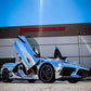 Chrome sports car with C8 vertical doors at-home installation by Vertical Doors Inc in front of building