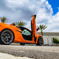 Orange C8 Z06 sports car with black accents featuring C8 Z06 vertical door kit open outdoors