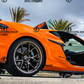 Orange C8 Z06 sports car equipped with C8 Z06 vertical door kit by Vertical Doors Inc in an outdoor setting