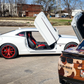 White Camaro with Camaro vertical doors kit installed featuring raised vertical doors and red rims