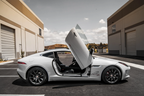 White Jaguar F-Type with Jaguar F-Type Lambo doors kit installed in urban parking lot
