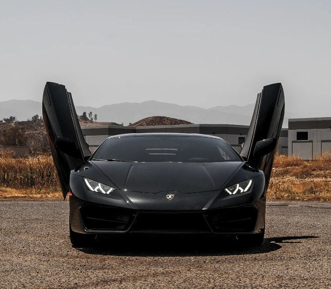 Black Lamborghini with open Huracan Lambo door kit in outdoor setting by Vertical Doors Inc