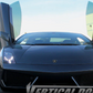 Black Lamborghini with Gallardo Lambo doors kit installed showing vertical door lift in outdoor setting