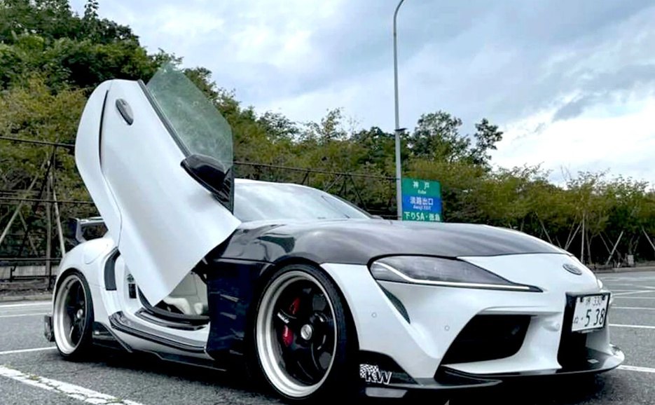 White Toyota Supra Mk5 with black hood featuring Toyota Supra Mk5 Lambo Doors open in a parking lot
