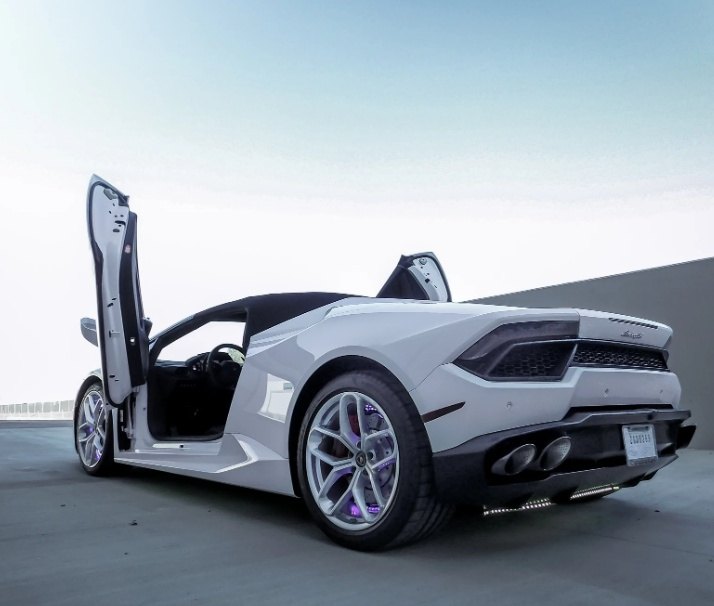 White Lamborghini Huracan with Huracan Lambo door kit open showing vertical doors on sports car