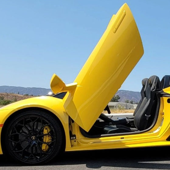 Yellow sports car with open Huracan Lambo door kit showing vertical door design and black wheels